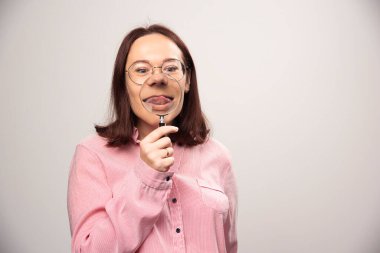 Beyaz arka planda büyüteç tutan bir kadının portresi. Yüksek kalite fotoğraf