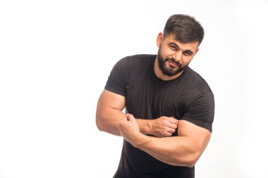 Siyah gömlekli sporcu pazılarını gösteriyor. Yüksek kalite fotoğraf