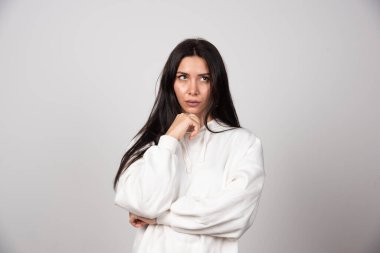 Düşünceli genç bir kadının portresi ayakta dikilip başka tarafa bakıyor. Yüksek kalite fotoğraf