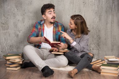 Genç bir çift ilginç bir kitap okuyor ve tartışıyor. Yüksek kalite fotoğraf