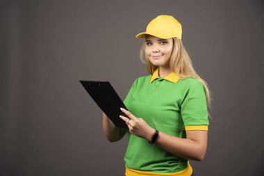 Kalem ve not panosuyla gülümseyen kadın kurye. Yüksek kalite fotoğraf