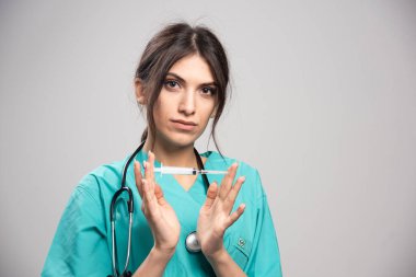 Steteskoplu kadın doktor elinde şırınga tutuyor. Yüksek kalite fotoğraf