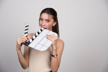 Gri arka planda alçıpan ısıran bir kadın. Yüksek kalite fotoğraf