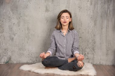 Lotus 'ta oturan genç çekici kadın meditasyon sırasında gözleri kapalı poz veriyor. Yüksek kalite fotoğraf