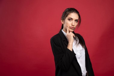 Kırmızı arka planda duran genç bir iş kadını. Yüksek kalite fotoğraf