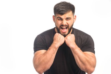 Siyah gömlekli adam yumruklarını gösteriyor. Yüksek kalite fotoğraf