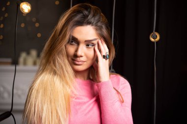 Lambaların yanında süveter giyen güzel bir kadın poz veriyor. Yüksek kalite fotoğraf