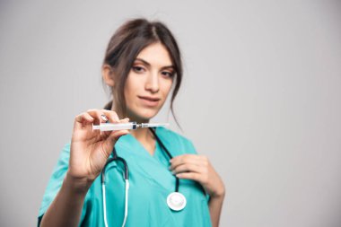 Steteskoplu kadın doktor elinde şırınga tutuyor. Yüksek kalite fotoğraf