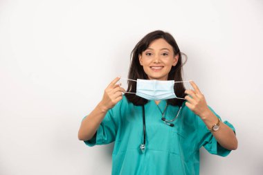 Beyaz arka planda maskesi olan bir kadın doktor. Yüksek kalite fotoğraf