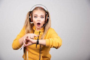 Sarı kazaklı güzel kadın zamanı görünce şaşırdı. Yüksek kalite fotoğraf