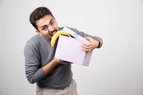 紫色の箱からバナナを取ろうとしている若い男 高品質の写真 — ストック写真