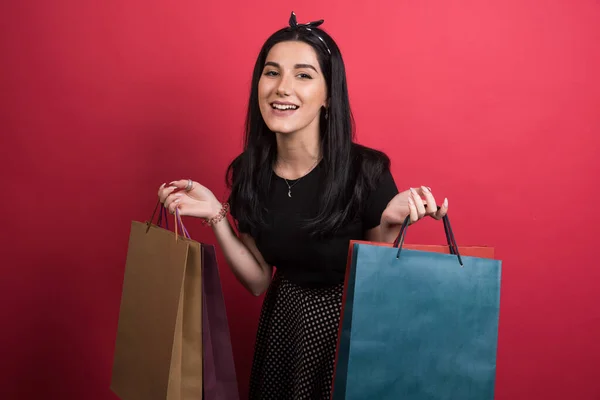 Vrouw Houden Haar Tassen Rode Achtergrond — Stockfoto