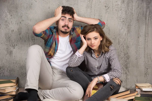若い夫婦が本を持って床に座っている写真 高品質の写真 — ストック写真