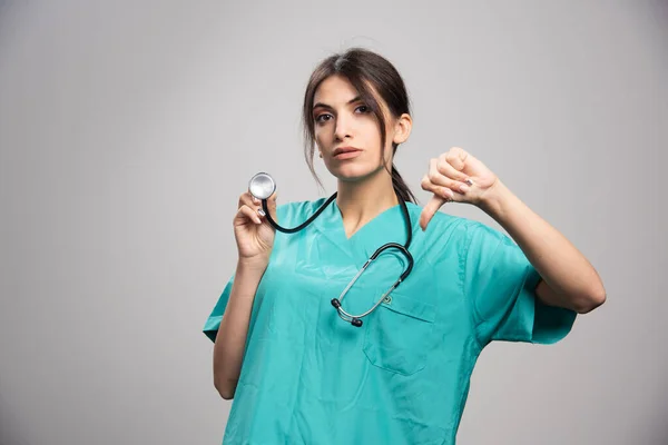 Médico Femenino Dando Pulgares Abajo Sobre Fondo Gris Foto Alta — Foto de Stock