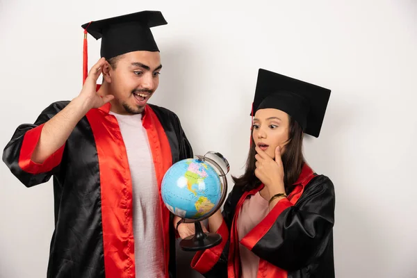 Pár Boldog Diák Köpenyben Nézi Földgömböt Fehér Háttéren Kiváló Minőségű — Stock Fotó