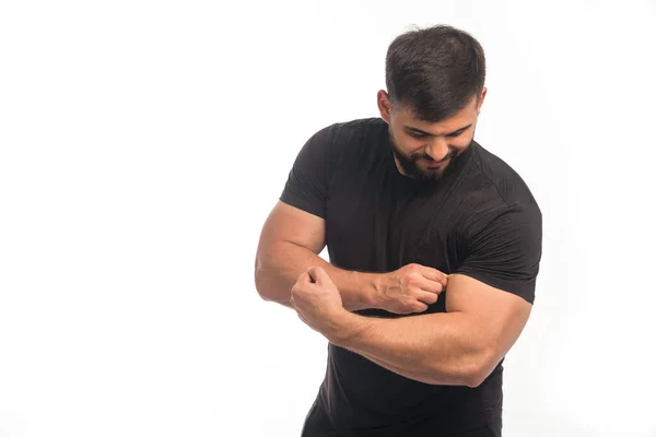 Sportowiec Czarnej Koszuli Pokazuje Swoje Bicepsy Wysokiej Jakości Zdjęcie — Zdjęcie stockowe