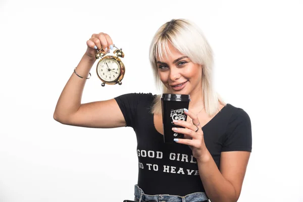 白い背景にコーヒーの時計とカップを持っている若い女性 高品質の写真 — ストック写真