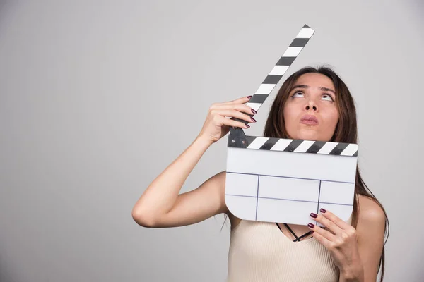 Jovem Mulher Com Clapperboard Olhando Cabeça Para Baixo Foto Alta — Fotografia de Stock