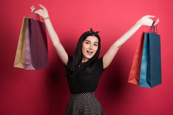 Vrouw Houden Haar Tassen Rode Achtergrond — Stockfoto