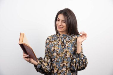 Beyaz arka planda kitap okuyan mutlu esmer kadın. Yüksek kalite fotoğraf