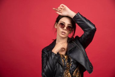 Siyah güneş gözlüğü takan siyah deri ceketli havalı kız. Yüksek kalite fotoğraf