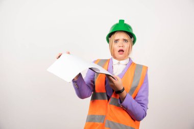 Yeşil başlıklı kadın müteahhit beyaz arka planda pano tutuyor. Yüksek kalite fotoğraf