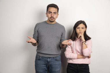 Beyaz arka planda düşünen genç bir çift. Yüksek kalite fotoğraf