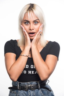 Şaşırmış bir kadın beyaz arka planda iki eliyle yüzünü tutuyor. Yüksek kalite fotoğraf