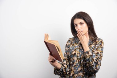 Esmer kadın beyaz arka planda kitap okuyor. Yüksek kalite fotoğraf