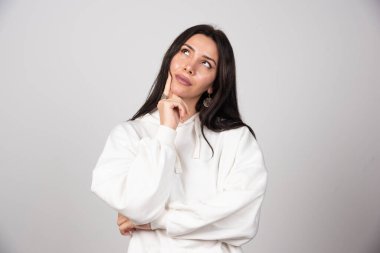 Düşünceli genç bir kadının portresi ayakta dikilip başka tarafa bakıyor. Yüksek kalite fotoğraf