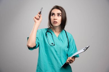 Dosyası olan kadın bir doktor ameliyat hakkında düşünüyor. Yüksek kalite fotoğraf