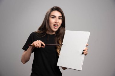 Siyah gömlekli kadın sanatçı fırça ve tuvalle poz veriyor. Yüksek kalite fotoğraf