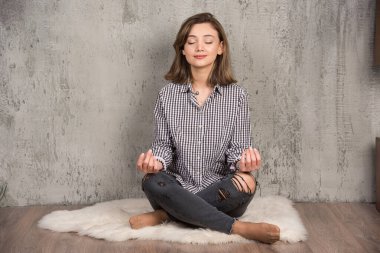 Lotus 'ta oturan genç çekici kadın meditasyon sırasında gözleri kapalı poz veriyor. Yüksek kalite fotoğraf