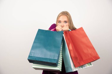 Beyaz arka planda alışveriş torbaları taşıyan sürpriz bir kadın. Yüksek kalite fotoğraf