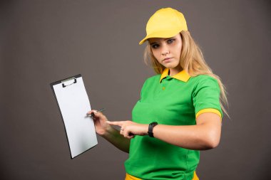 Panoya kalem doğrultmuş genç bir kadın kurye. Yüksek kalite fotoğraf