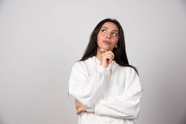 Düşünceli genç bir kadının portresi ayakta dikilip başka tarafa bakıyor. Yüksek kalite fotoğraf