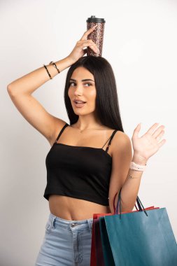 Kafasının üstünde kahve tutan güzel bir kadın. Yüksek kalite fotoğraf