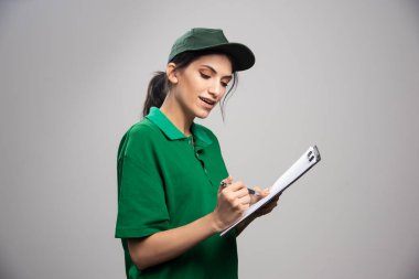 Gri arka planda panoya yazı yazan güzel bir kadın. Yüksek kalite fotoğraf