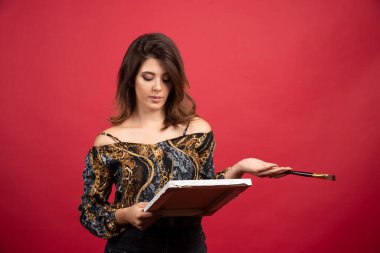 Ressam kız tuvaline bakıyor ve olumlu düşünüyor. Yüksek kalite fotoğraf