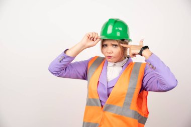 Beyaz arka planda miğferli genç bir kadın inşaatçı. Yüksek kalite fotoğraf