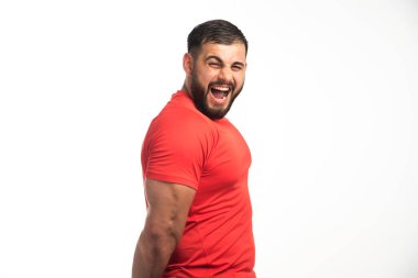 Kırmızı gömlekli sporcu kol kaslarını gösteriyor ve çığlık atıyor. Yüksek kalite fotoğraf