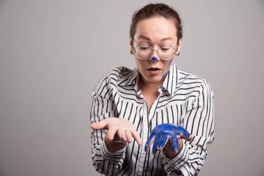 Gri arka planda resimlerini gösteren kadın. 