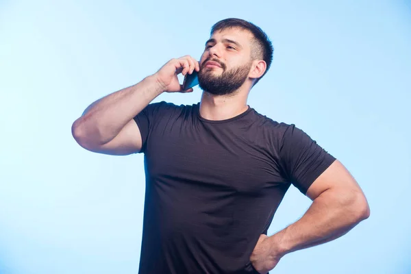 Uomo Sportivo Camicia Nera Tiene Telefono Parla Foto Alta Qualità — Foto Stock