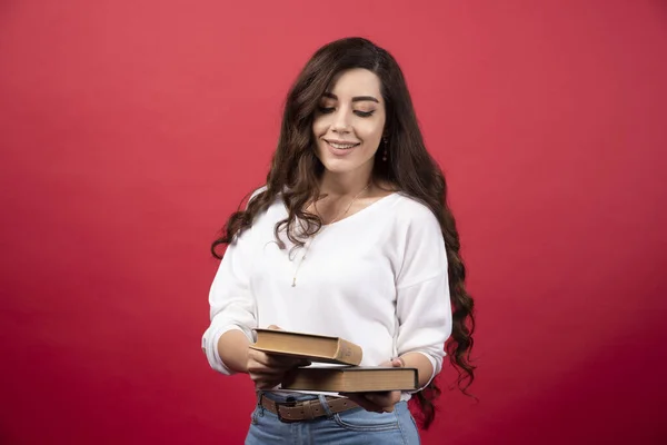 Mujer Morena Posando Con Libro Sobre Fondo Rojo Foto Alta — Foto de Stock