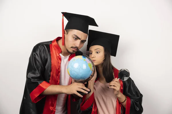 Friss Diplomás Diákok Köpenyben Nézik Földgömböt Fehér Háttéren Kiváló Minőségű — Stock Fotó