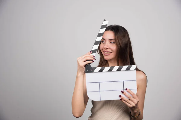 Wanita Tersenyum Memegang Film Clapperboard Atas Latar Belakang Abu Abu — Stok Foto