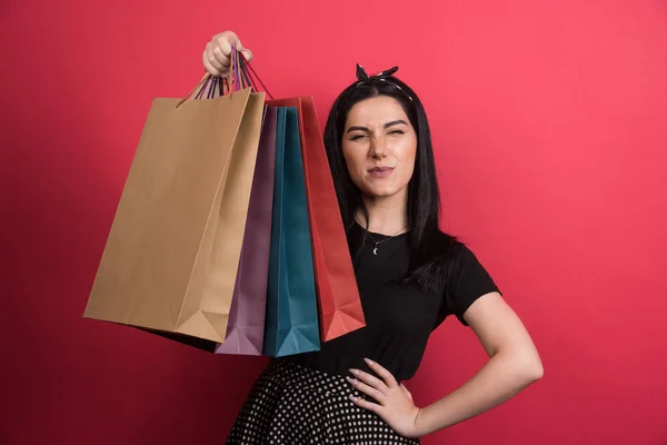 Vrouw Tonen Haar Tassen Rode Achtergrond — Stockfoto