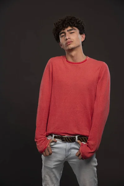 穿着红衫的年轻模特儿用手摸着衣袋摆姿势 高质量的照片 — 图库照片