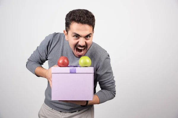 Een Schreeuwende Man Met Een Paarse Doos Met Appels Hoge — Stockfoto