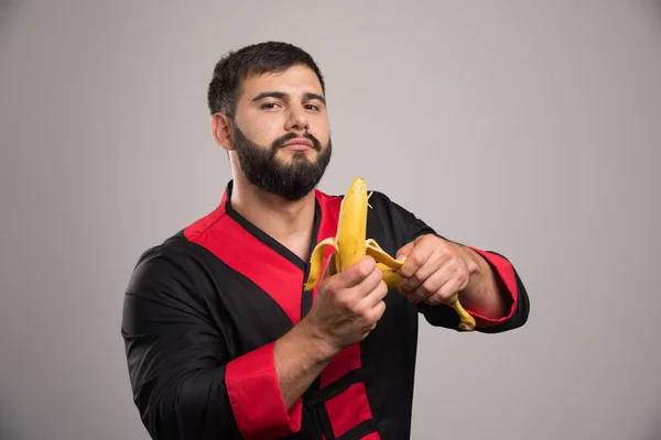 Giovane Che Sbuccia Una Banana Sfondo Scuro Foto Alta Qualità — Foto Stock